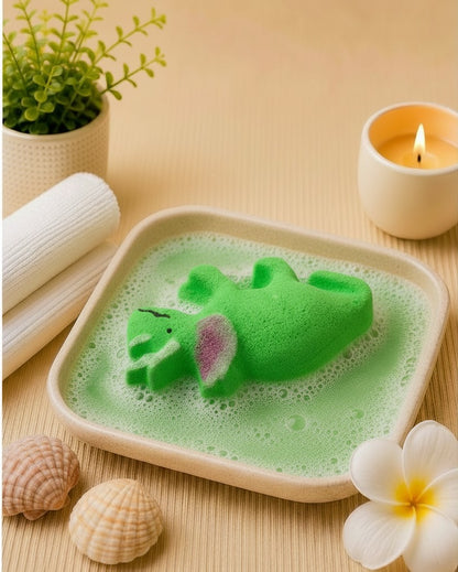 Calla Lily Cosmetics + CL kids green triceratops dinosaur bath bomb fizzing in a dish with citrus scent