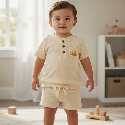 Calla Lily Cosmetics + CL kids off-white waffle knit top and shorts set with embroidered sun detail. Cotton-polyester blend.