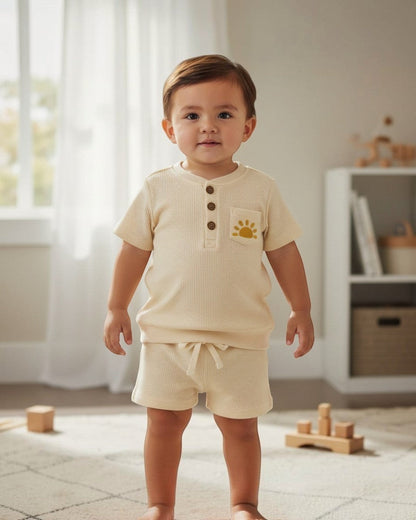 Calla Lily Cosmetics + CL kids off-white waffle knit top and shorts set with embroidered sun detail. Cotton-polyester blend.