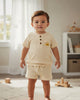 Calla Lily Cosmetics + CL kids off-white waffle knit top and shorts set with embroidered sun detail. Cotton-polyester blend.
