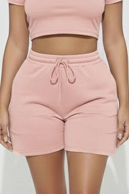 Calla Lily Cosmetics + CL kids pink cotton blend crop tee and drawstring shorts set on a model.