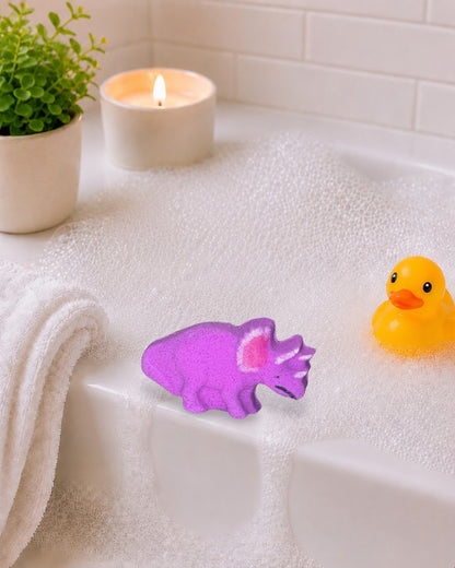 Calla Lily Cosmetics + CL kids purple triceratops dinosaur bath bomb with grape scent on a white wooden background