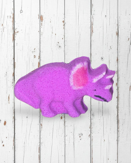 Calla Lily Cosmetics + CL kids purple triceratops dinosaur bath bomb with grape scent on a white wooden background