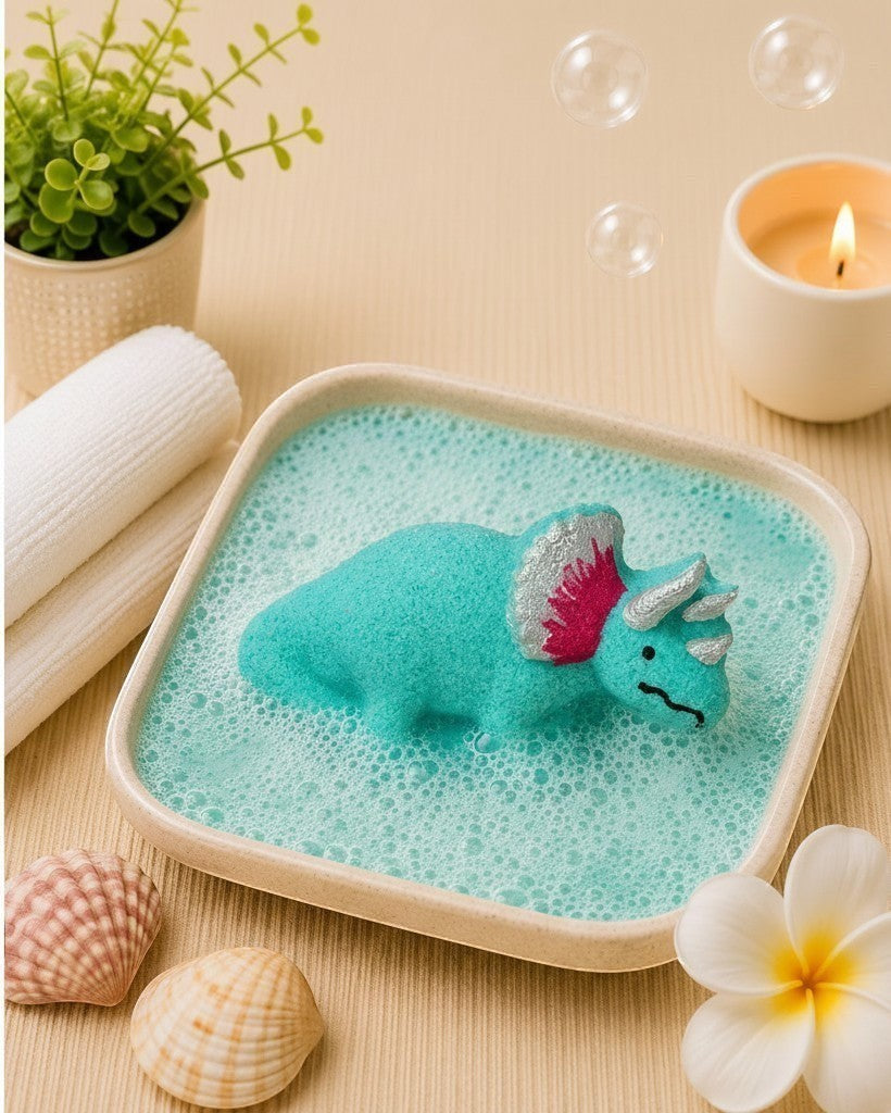 Calla Lily Cosmetics + CL kids teal triceratops dinosaur bath bomb fizzing in a bowl of water with floral scent