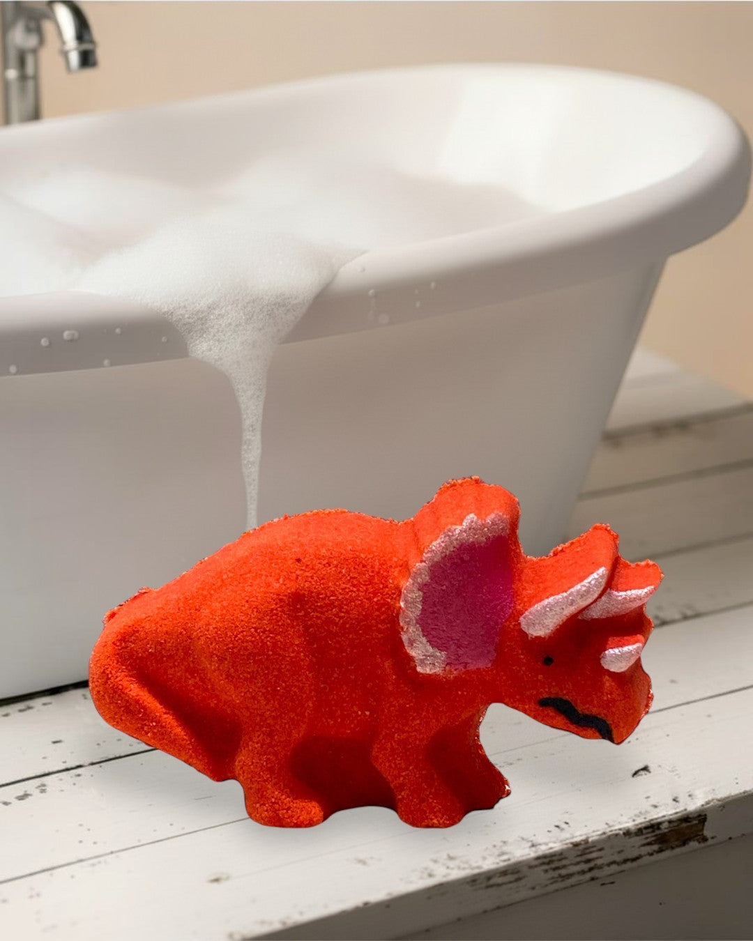 Calla Lily Cosmetics + CL kids red orange triceratops dinosaur bath bomb with strawberry blood orange scent.