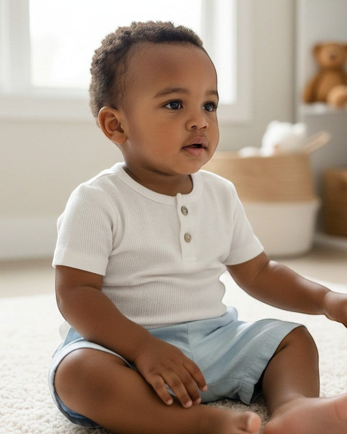 Calla Lily Cosmetics + CL kids white ribbed short-sleeve baby tee with two button closure.