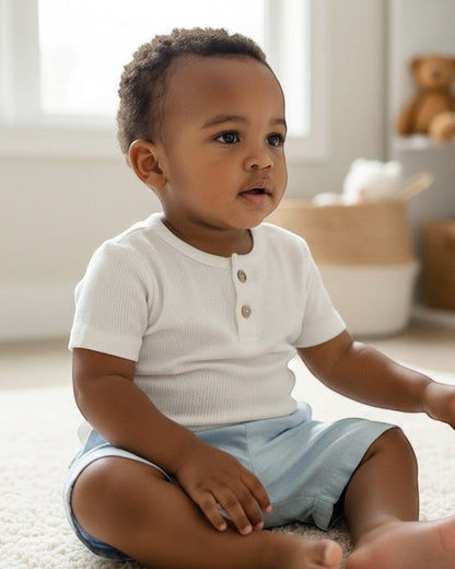 Calla Lily Cosmetics + CL kids white ribbed short-sleeve baby tee with two button closure.