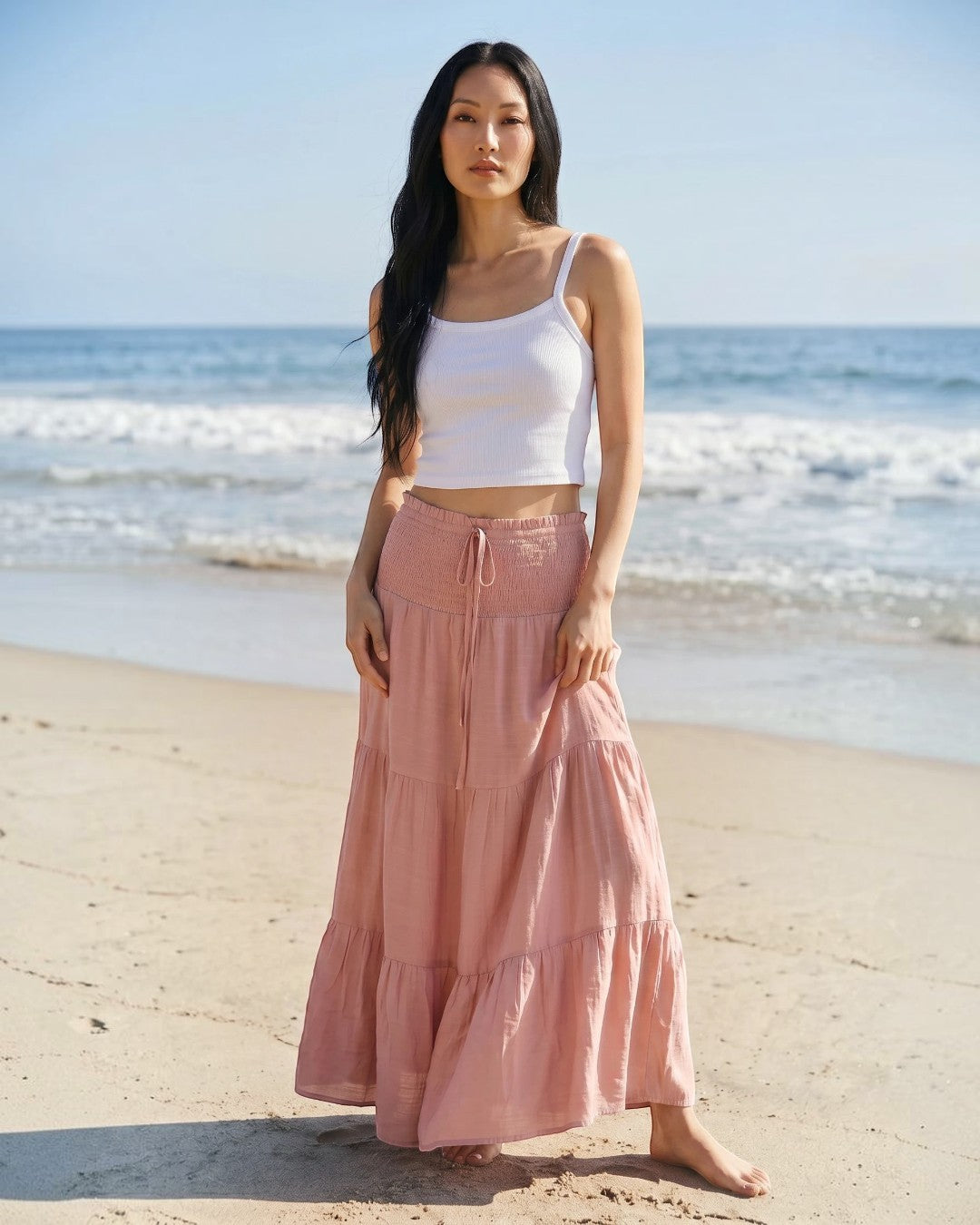 Calla Lily Cosmetics + CL kids white ribbed knit crop tank top worn by a model on a sunny beach.