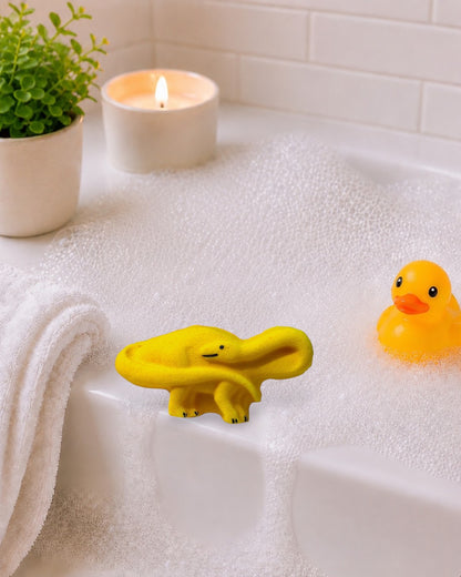 Calla Lily Cosmetics + CL kids yellow brontosaurus shaped pineapple scented bath bomb on a white wood background