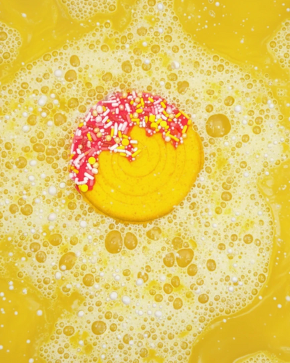 Calla Lily Cosmetics + CL kids yellow pineapple-scented lollipop bath bomb fizzing in a bubbly bath with sprinkles
