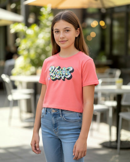 Calla Lily Cosmetics + CL kids coral pink cotton blend crop tee with a retro-style "Unique" graphic featuring flowers and a small pink flower accent.