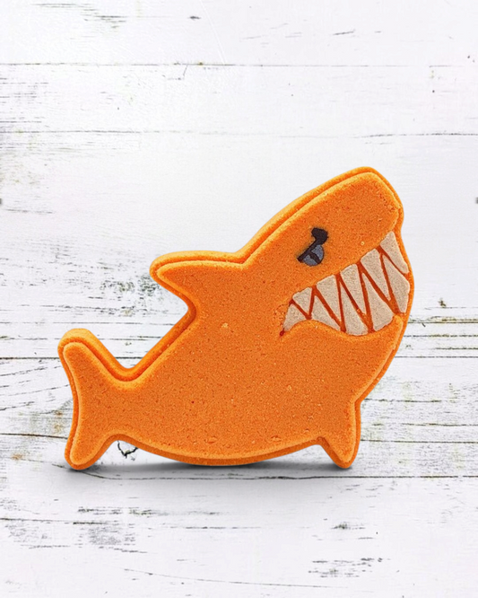 Calla Lily Cosmetics + CL kids orange shark-shaped bath bomb with strawberry banana scent and nourishing cocoa butter.