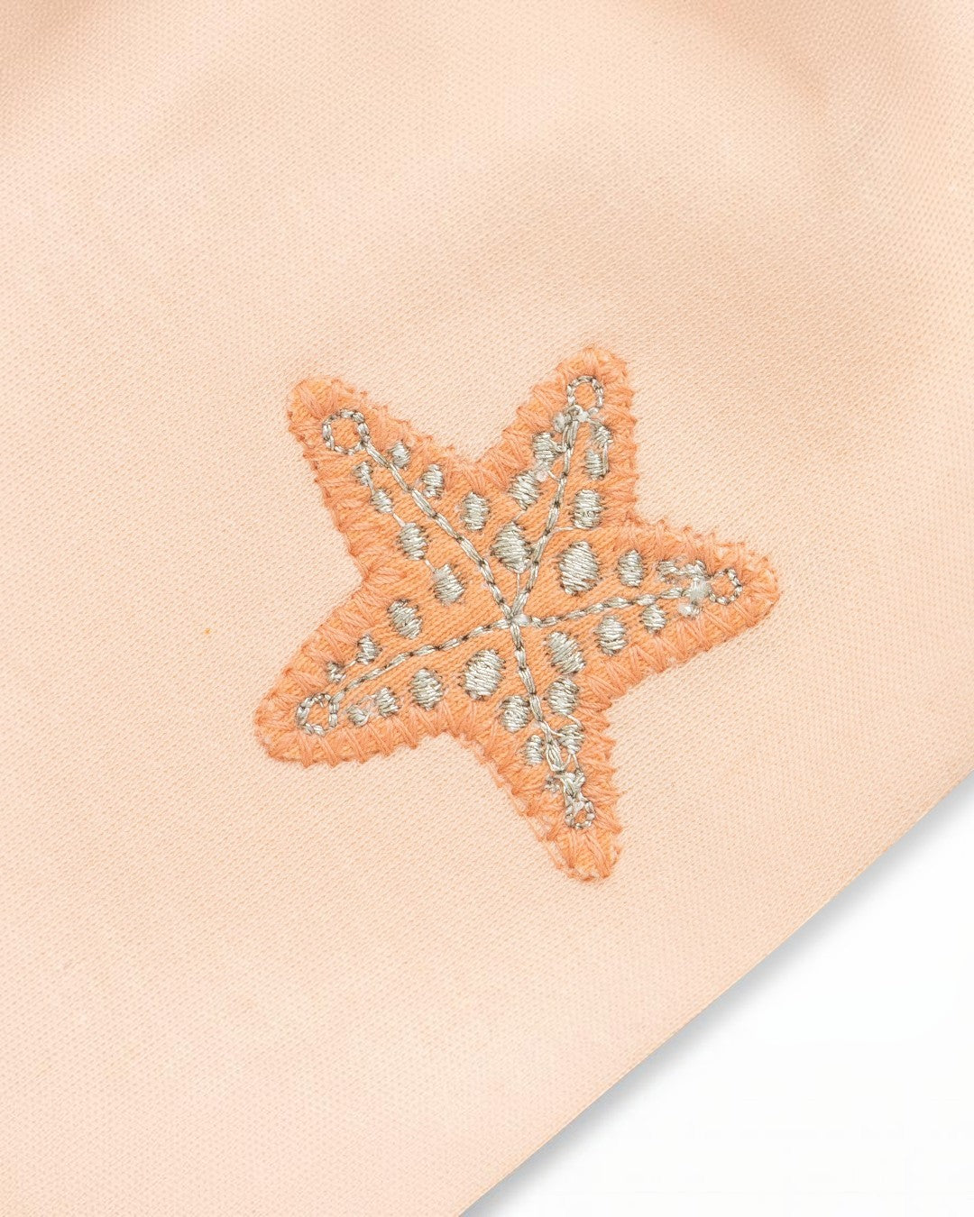 Starfish-shaped patch with decorative elements on a beige background