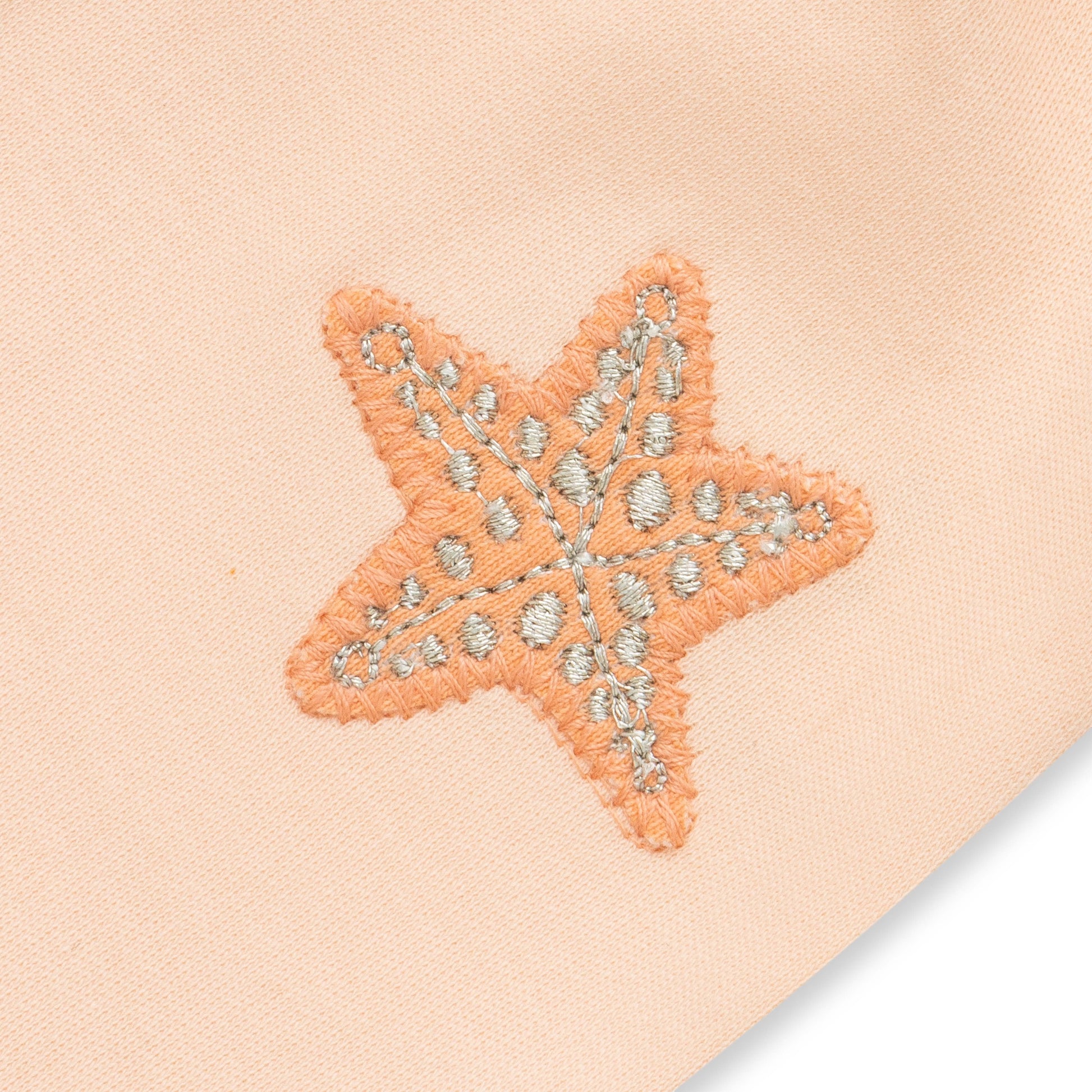 Starfish-shaped patch with decorative elements on a beige background