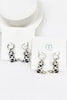 Cowboy boot earrings on a white card with a brand logo.