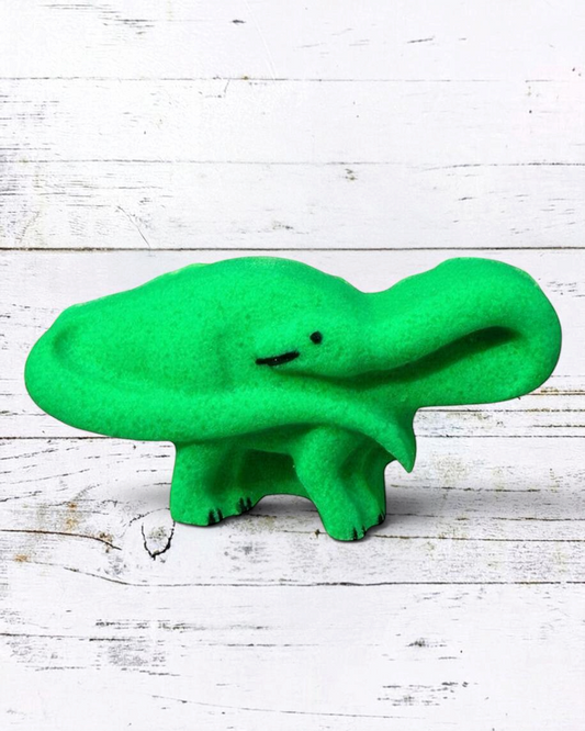 Calla Lily Cosmetics + CL kids green brontosaurus dinosaur bath bomb with citrus scent on a white wood background