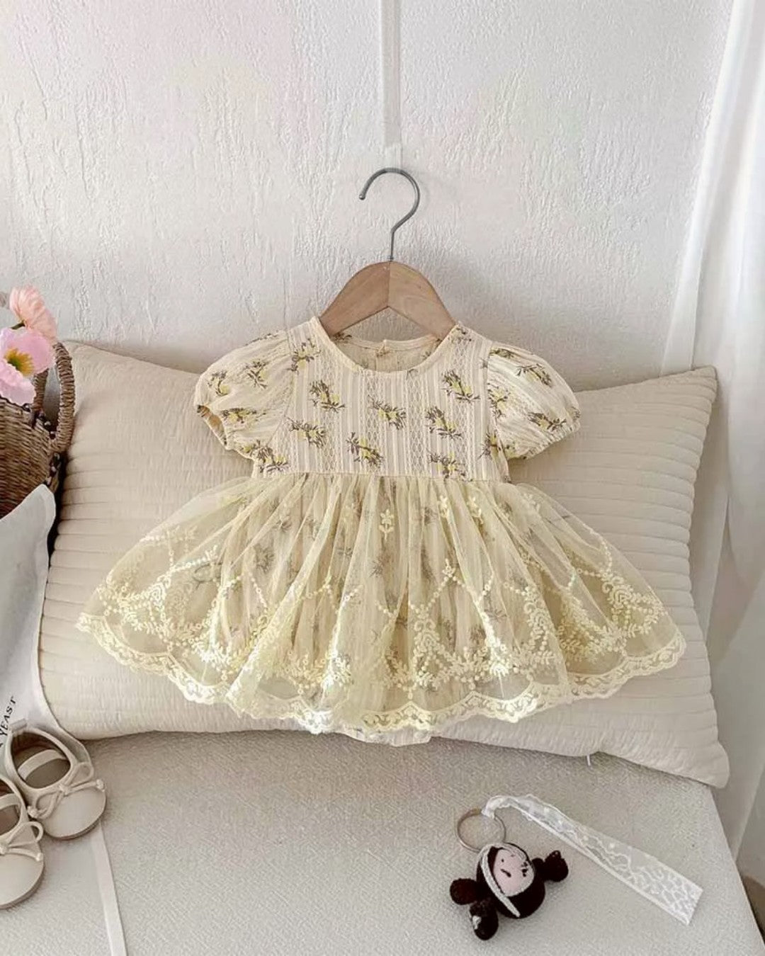 Delicate lace dress on a hanger against a neutral background