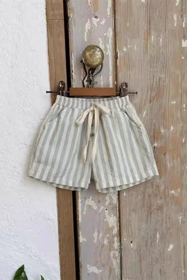 Striped shorts hanging on a wooden door with a white wall background