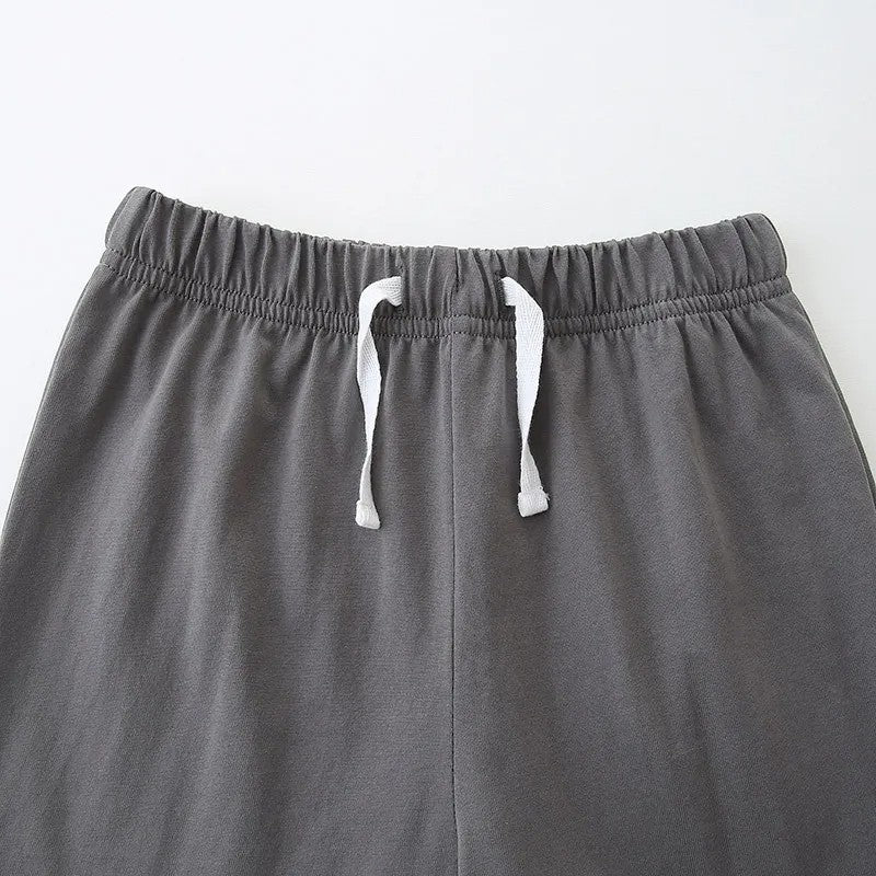 Gray sweatpants with white drawstrings on a light gray background