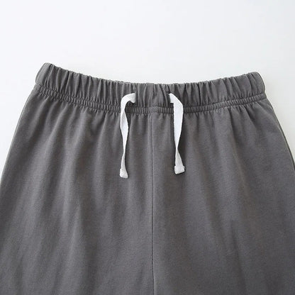 Gray sweatpants with white drawstrings on a light gray background