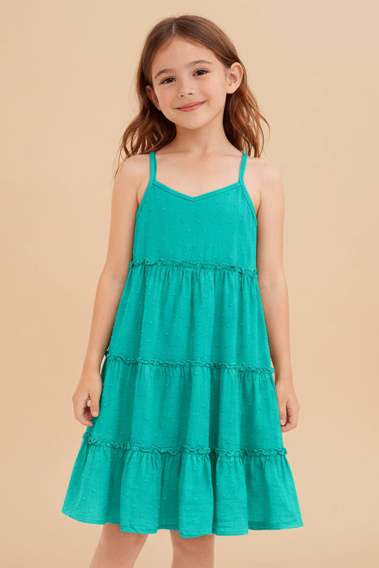 Young girl wearing a teal dress on a white background