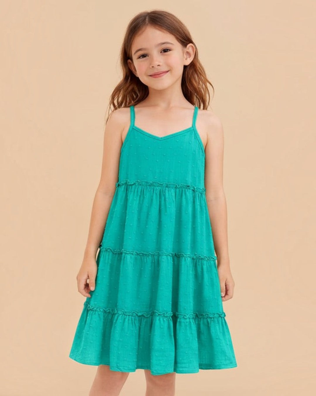 Young girl wearing a teal dress on a white background