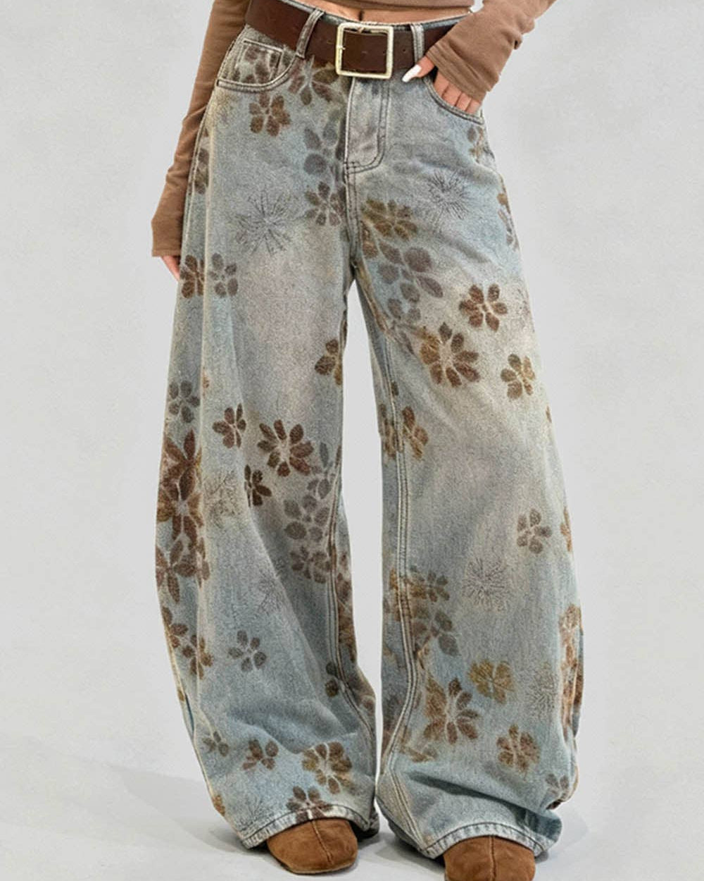 Floral-patterned wide-leg jeans worn by a person on a plain background
