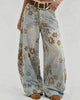 Floral-patterned wide-leg jeans worn by a person on a plain background