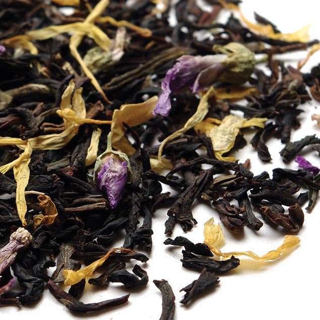 Assorted dried black tea leaves with flowers on a white background