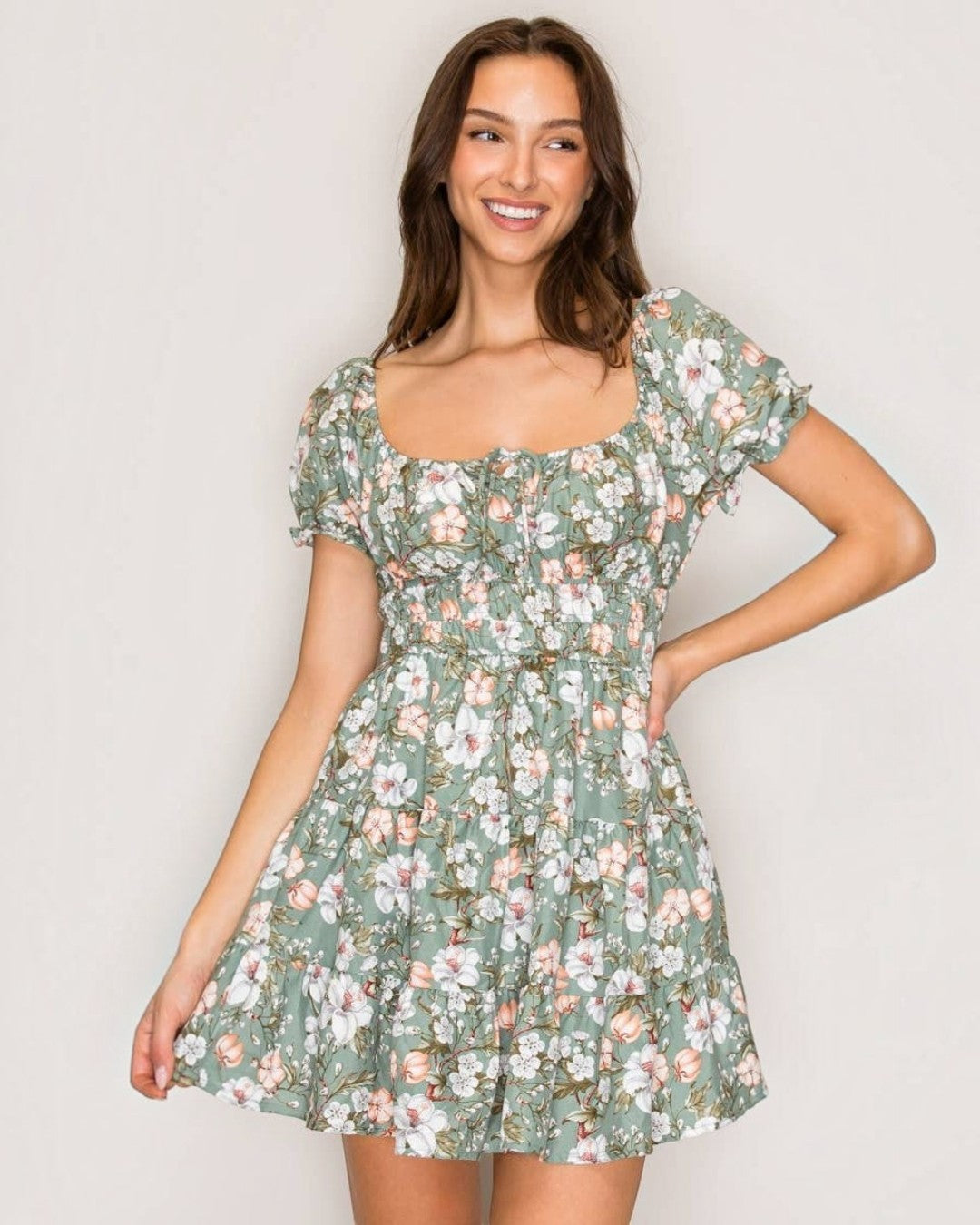 Woman wearing a floral dress against a plain background