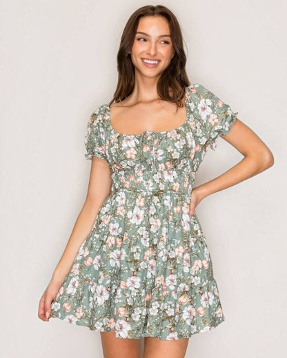 Woman wearing a floral dress against a plain background