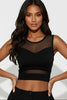 Woman wearing a black sheer top against a white background