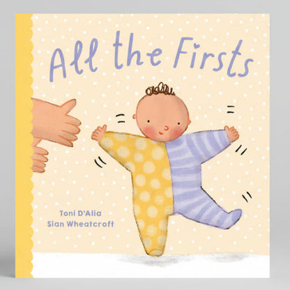 Book cover of 'All the Firsts' with a baby and adult hand illustration on a polka dot background.