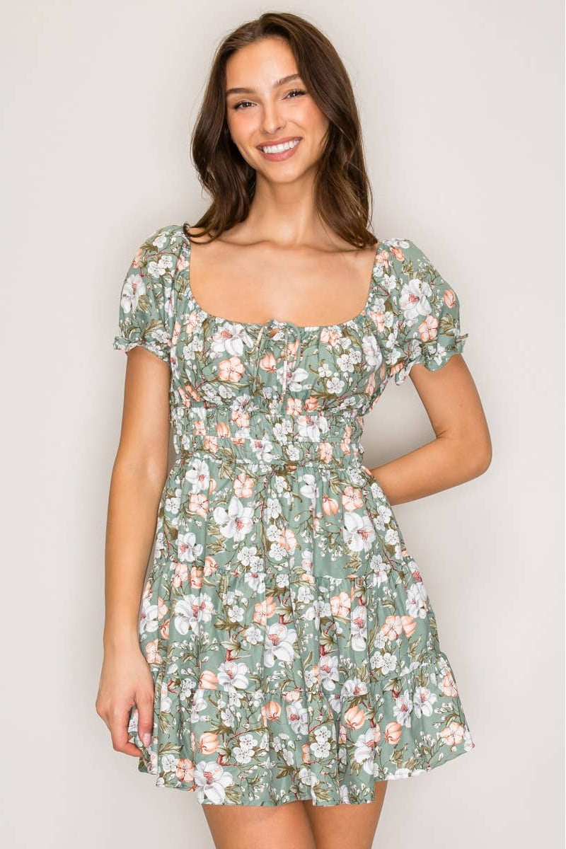 Woman wearing a floral dress against a plain background