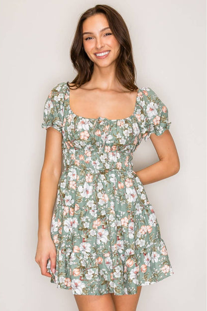 Woman wearing a floral dress against a plain background