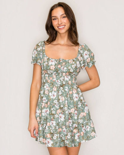 Woman wearing a floral dress against a plain background