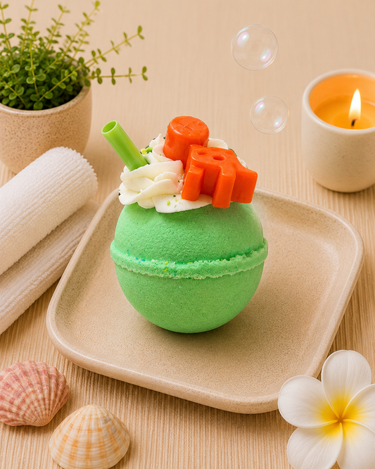 Green bath bomb with decorative elements on a beige tray, surrounded by bubbles, shells, and a candle.