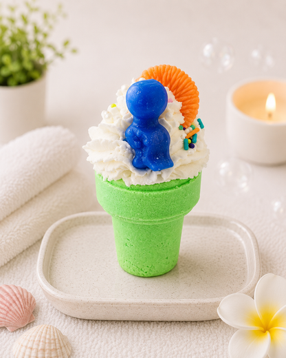 Green ice cream cone-shaped dessert with whipped cream, blue character, and orange shell on a white surface.