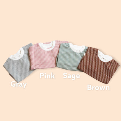 Four shirts in gray, pink, sage, and brown on a beige background with color labels.