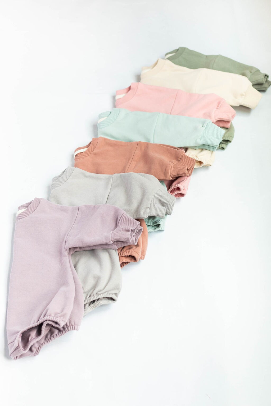 Stack of colorful baby bloomers on a white background