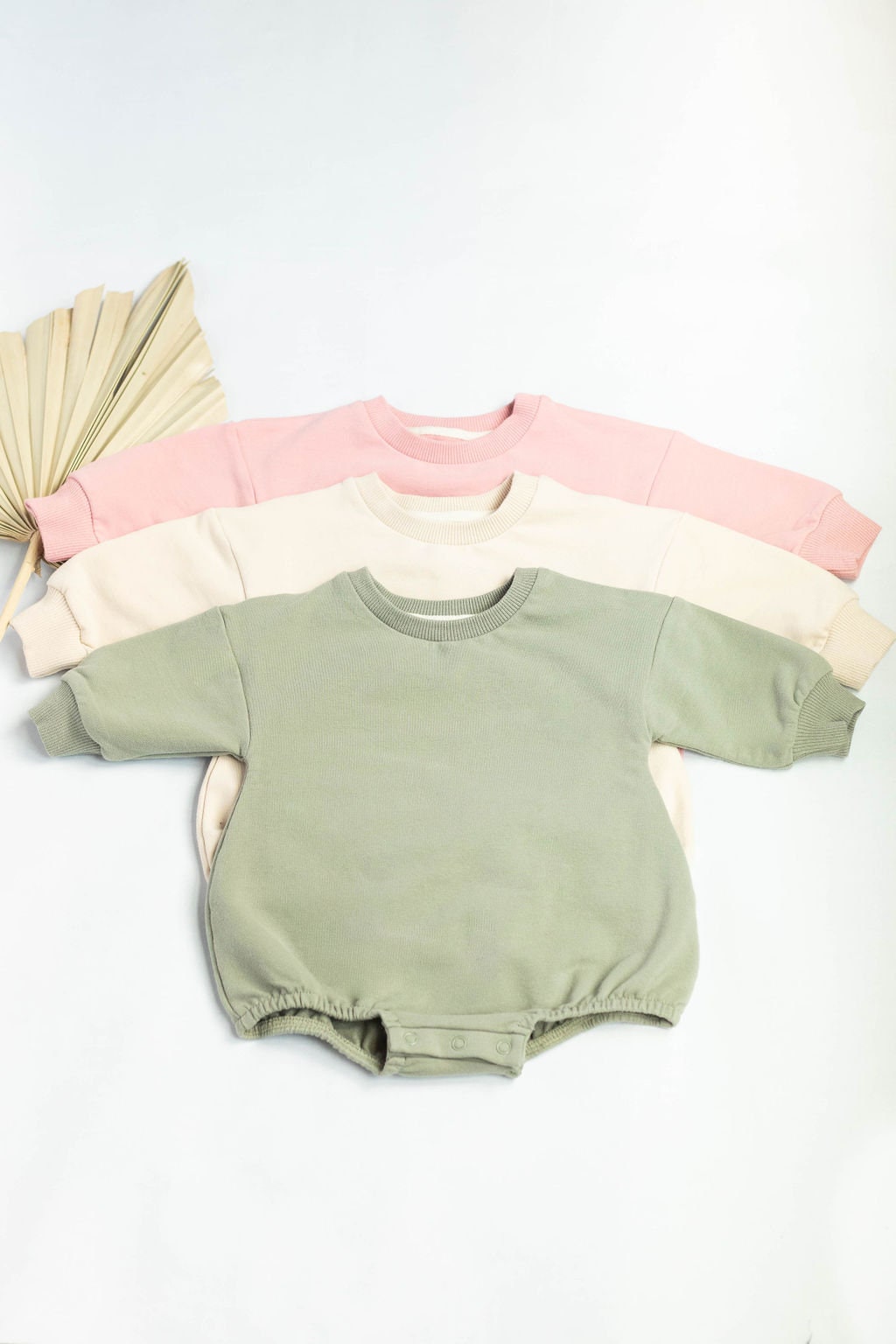 Set of baby rompers in pastel colors on a white background