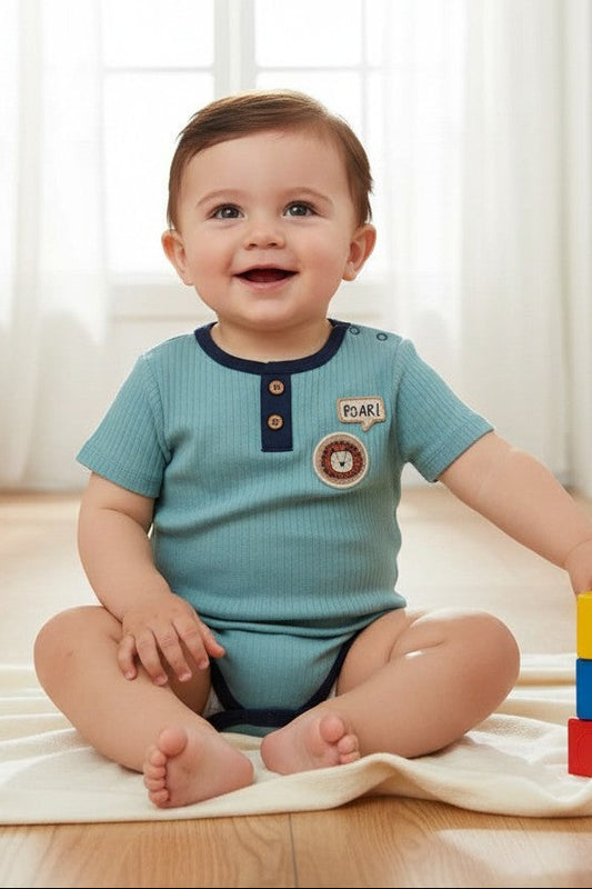 Baby sitting on a blanket with colorful blocks in a room with a bookshelf and chair.