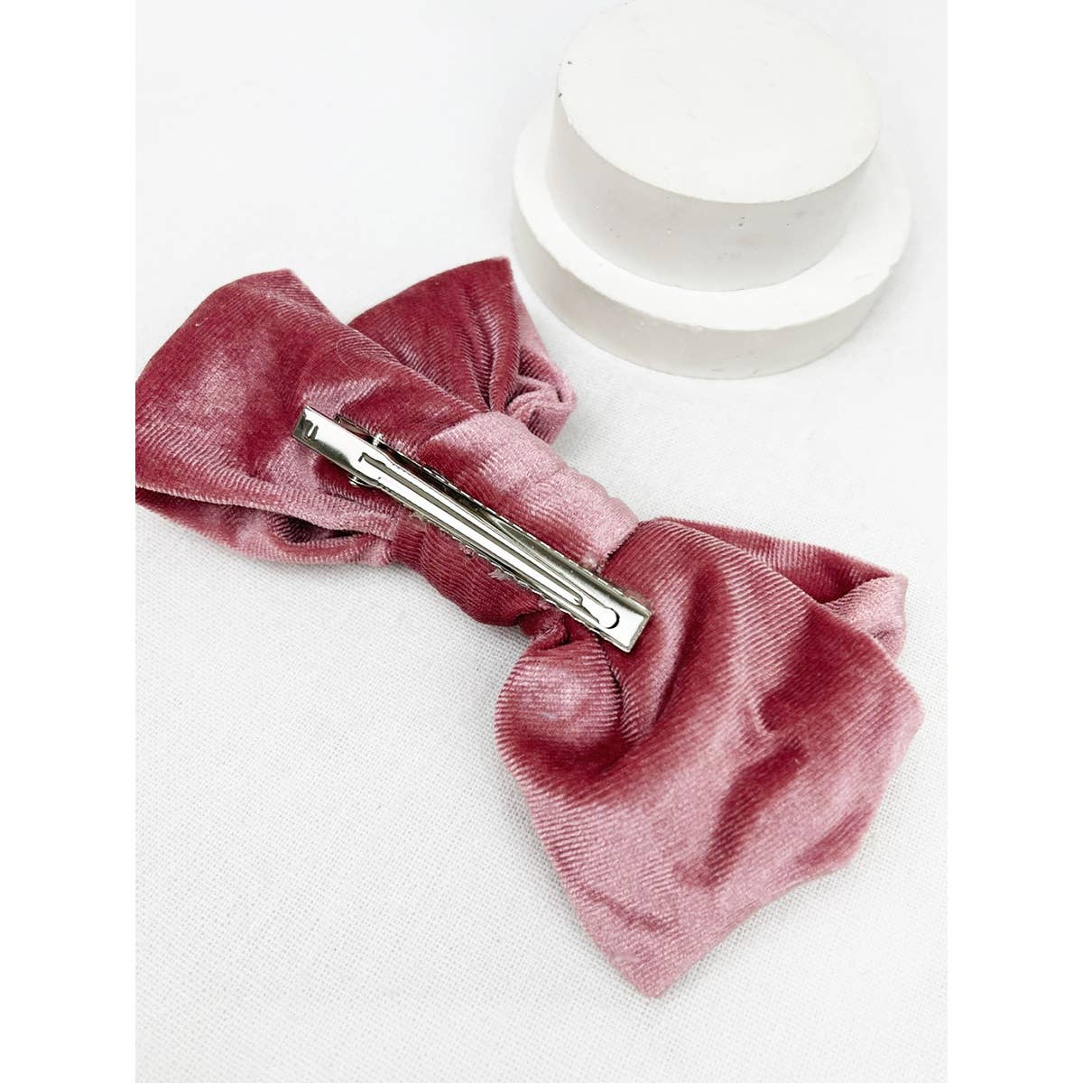 Pink bow
 with a silver clip on a white background