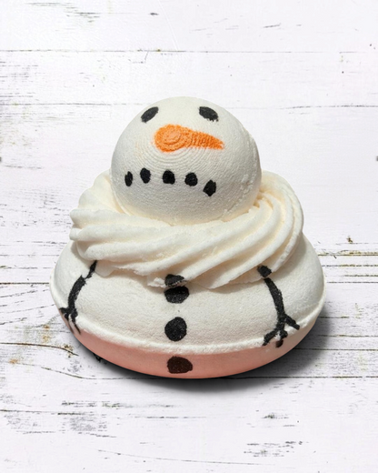 Calla Lily Cosmetics + CL kids hand-painted white snowman bath bomb with orange nose and black details in a hand