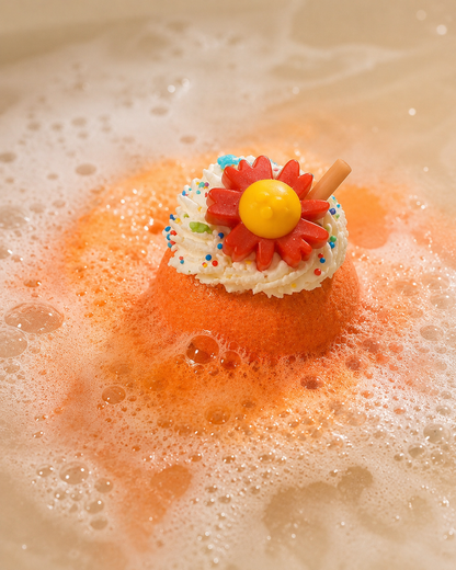 Colorful bath bomb with a floral design floating in bubbles.