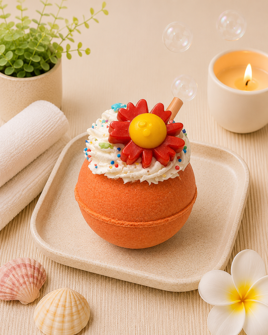 Bath bomb with colorful flower on top on a tray with bubbles and a candle in the background