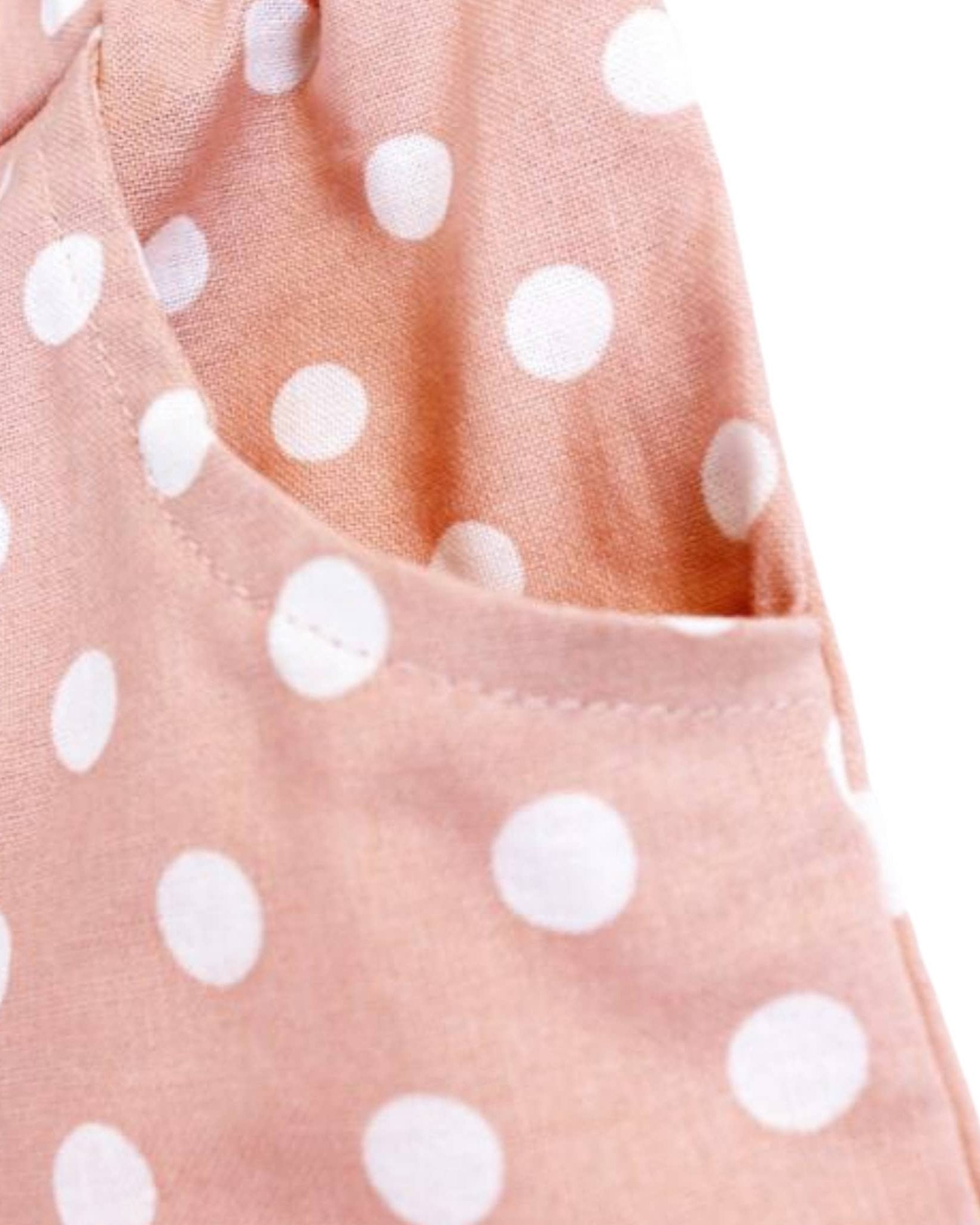 Close-up of a pink fabric with white polka dots