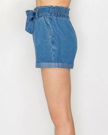 Denim shorts worn by a person on a white background