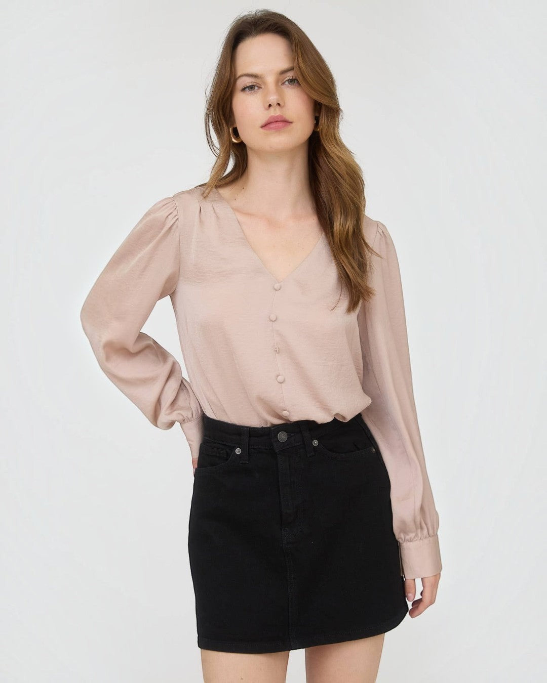 Woman wearing a beige blouse and black skirt on a white background