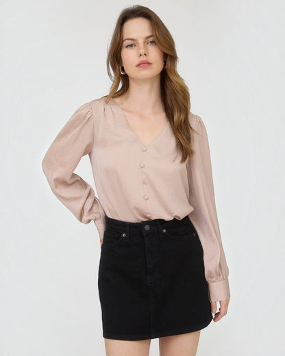 Woman wearing a beige blouse and black skirt on a white background